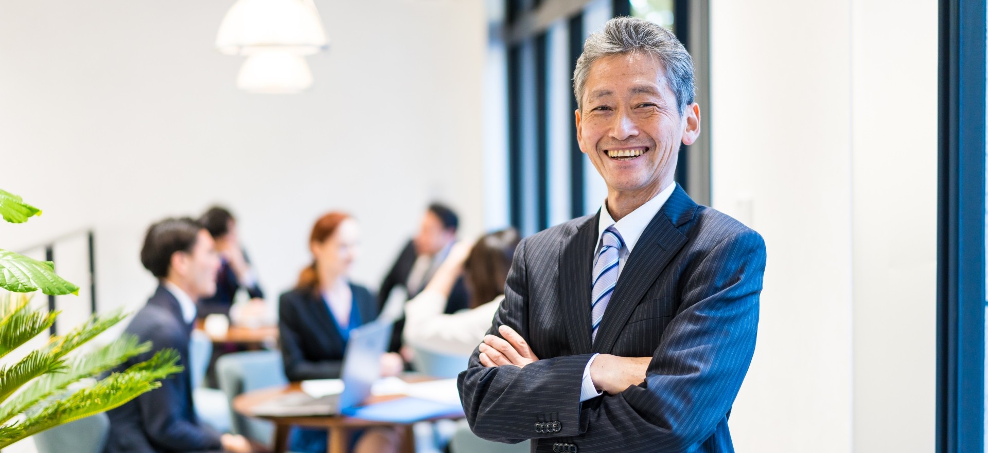 社長や経営層が笑顔で社員を見守る様子。トップによる承認と職場エンゲージメント向上