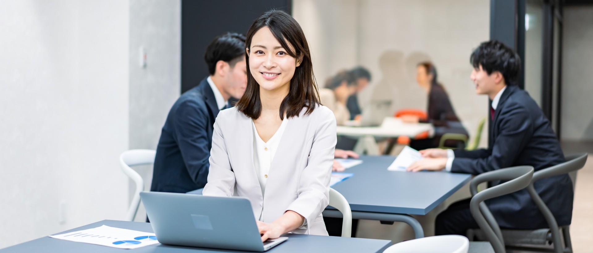 オフィスで働く女性社員とチームの会議風景|感謝と承認が生まれる職場のイメージ